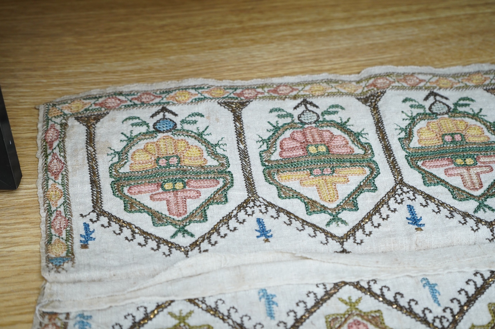 Two 19th century Turkish hand embroidered towel ends sewn together later as a table centre. Worked on fine hand woven linen in polychrome silks with gold metallic thread fillings, 39.5cm wide x 26.5cm deep. Condition - t